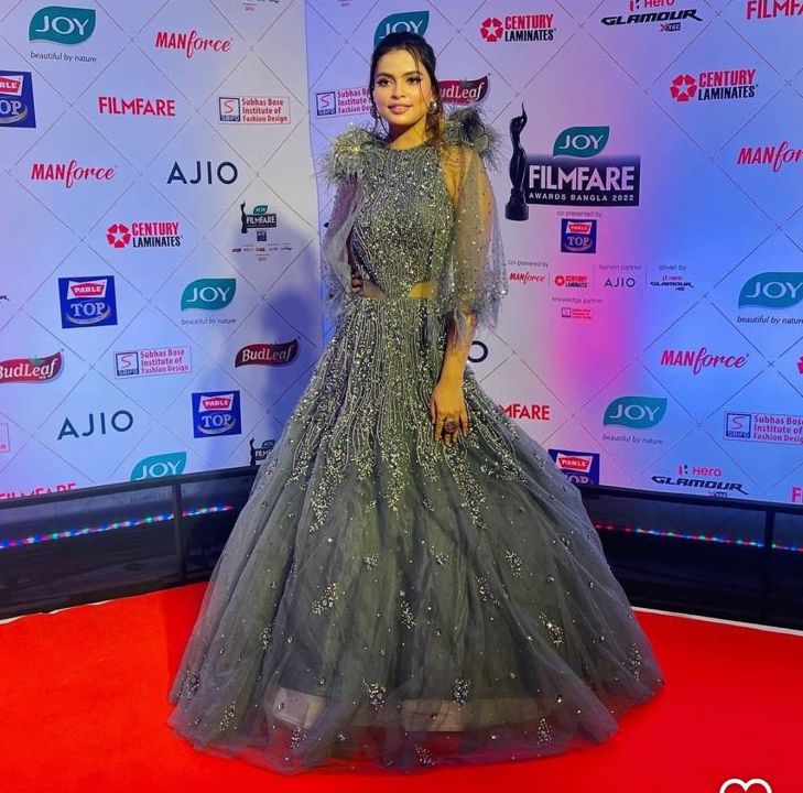 Designer moss green net gown with scalloped embroidered feather cape