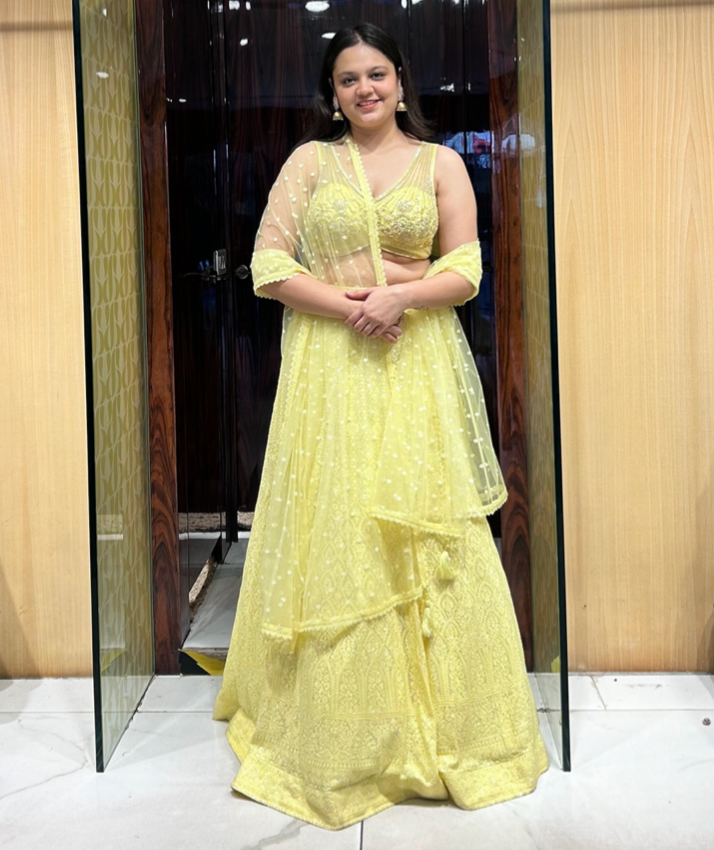 Naelle Lemon Yellow Lehenga with Lucknowi chikankari embroidery, sequins, pearls, stones, and net dupatta with crystal hangings.