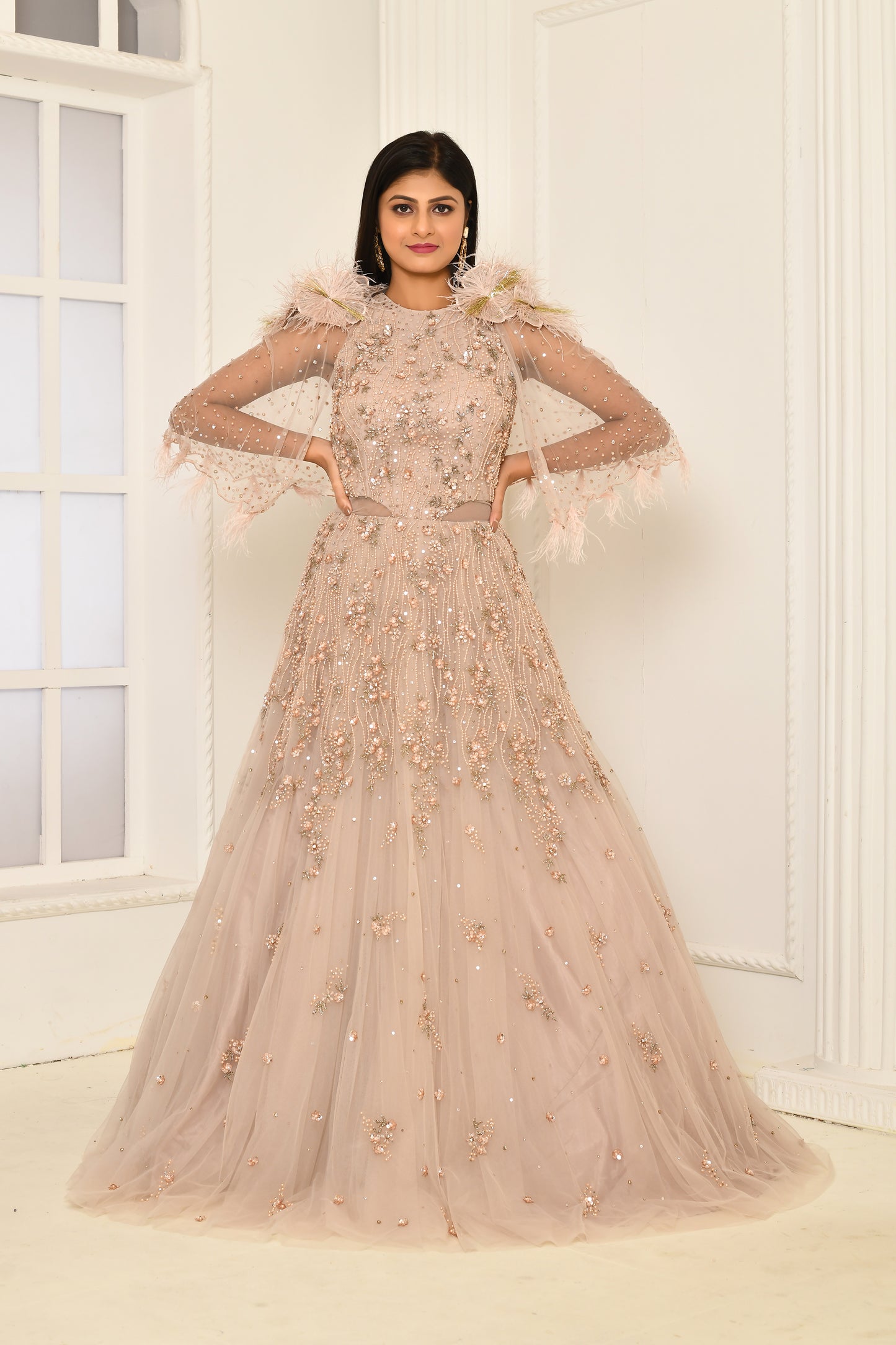 Feather and flower patch details on shoulder of cape gown for sangeet or reception