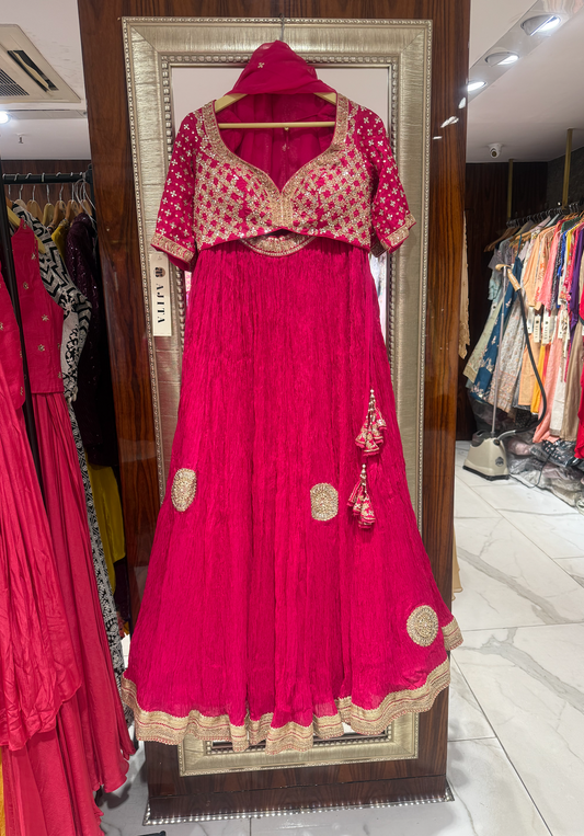 Magenta designer anarkali with gold embroidered jacket and tasseled waist – great for wedding sangeet or reception nights.