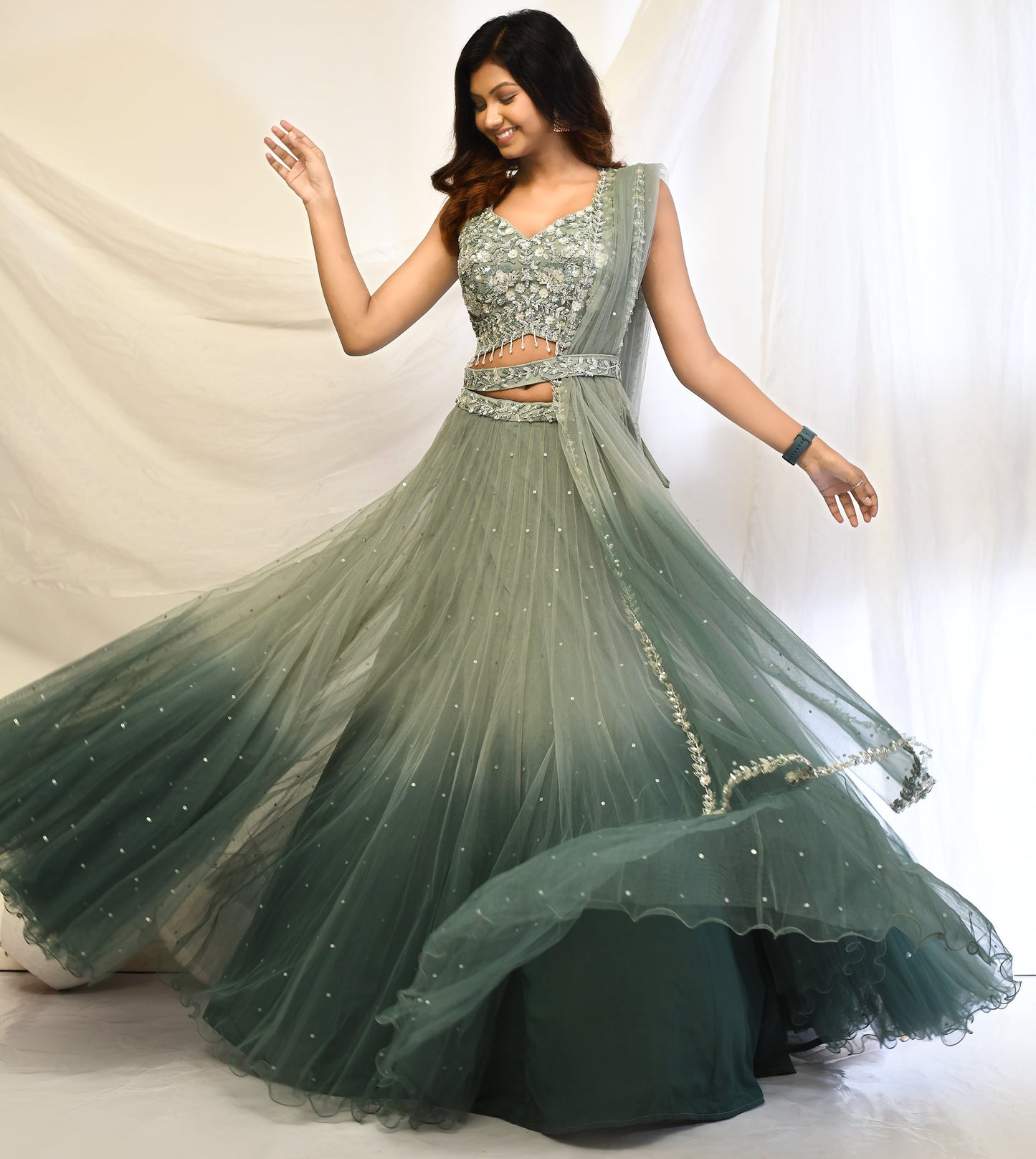 Jayanti Ombre green net lehenga with sequin and cut dana embroidery, belted waist, and four-side border dupatta – elegant festive ensemble.  
