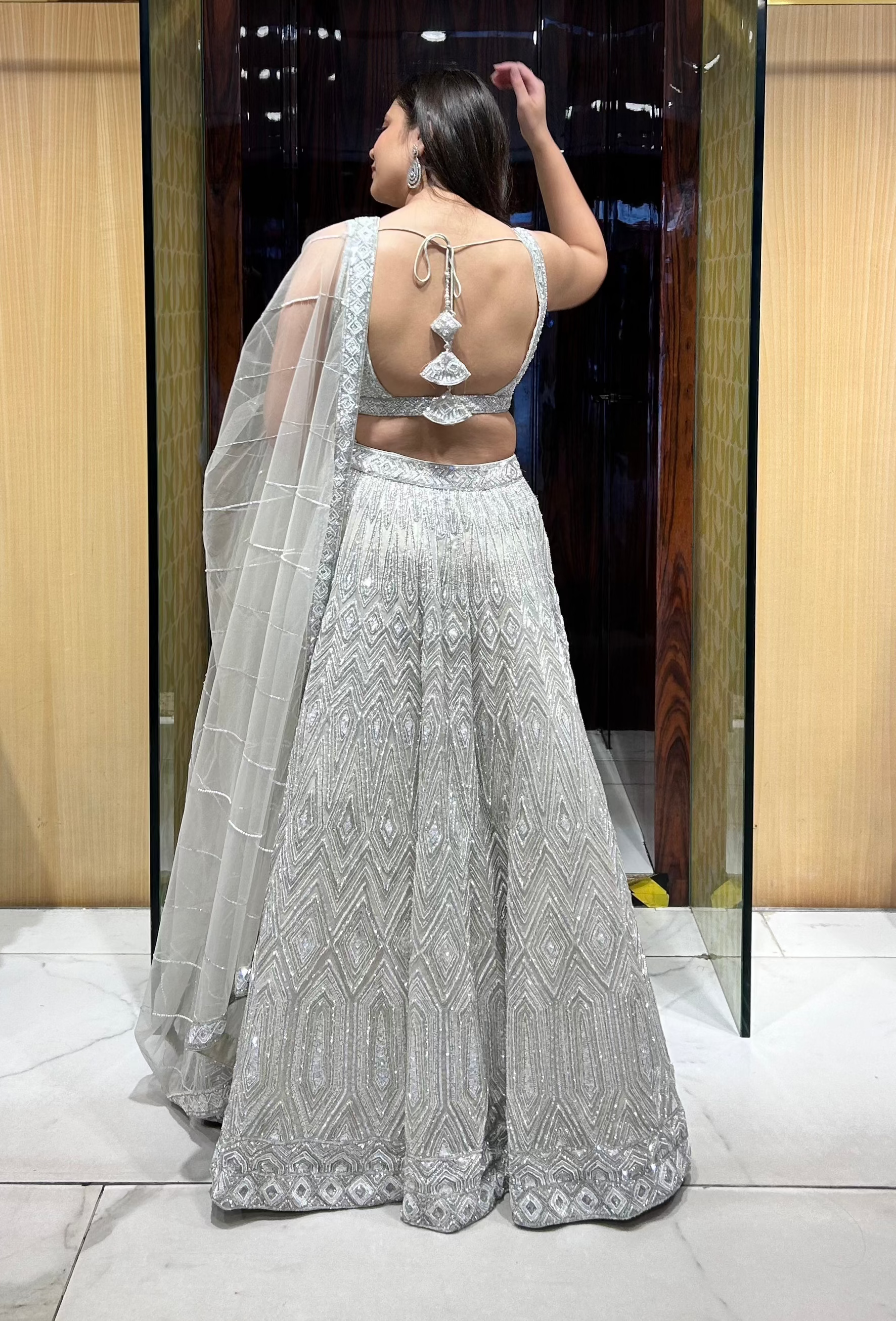 Front view of champagne organza lehenga with sequin and pearl detailing